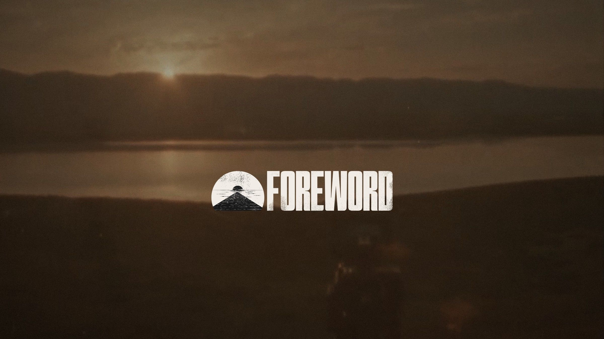 The Foreword wordmark and semicircle sunset mark in cream, over a warm Super 8 film frame of the sun setting behind hills and a lake